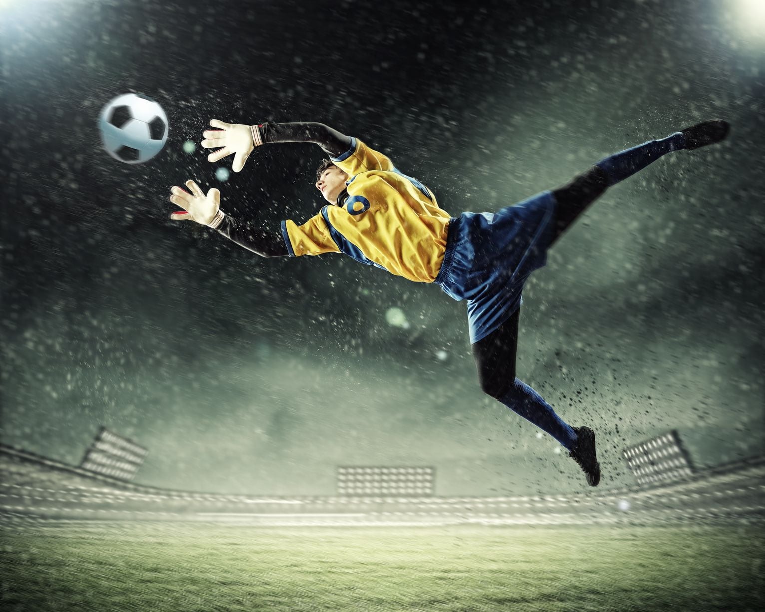 A goalkeeper stretched full-length in mid-air to reach the ball
